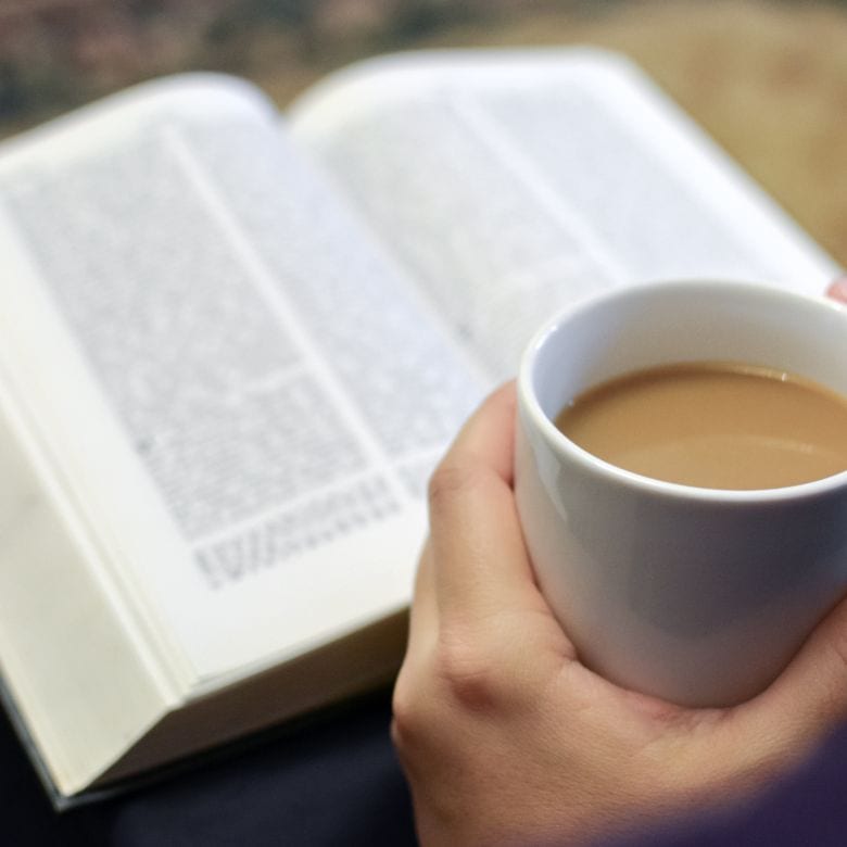 Woman drinking coffee and reading Bible