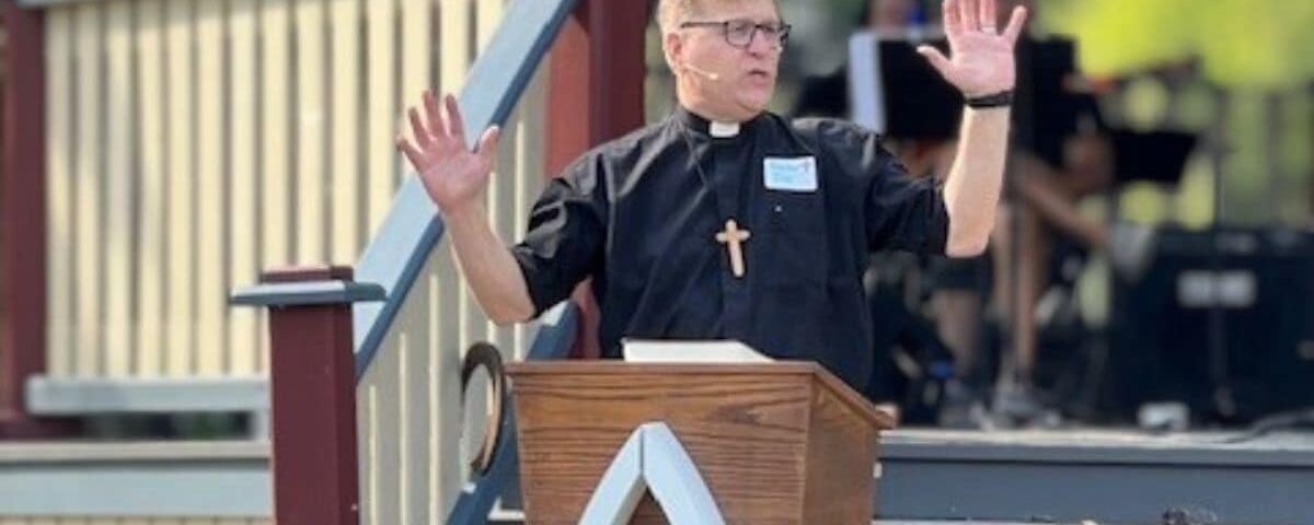 Pastor Joe Glombicki preaching outside at park at Bethlehem Lutheran Church in West Dundee, IL